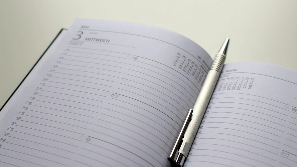 Agenda ouvert sur une page datée, un stylo posé au centre