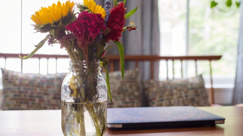 Bouquet de fleurs et ordinateur portable sur une table en bois